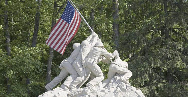 Statue of a military figures placing an American flag on the ground