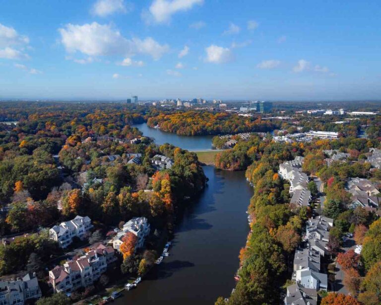 Aerial view of Lake Audubon and Lake Thoreau in Reston, Virginia, with fall foliage and Reston Town Center towers on the horizon
