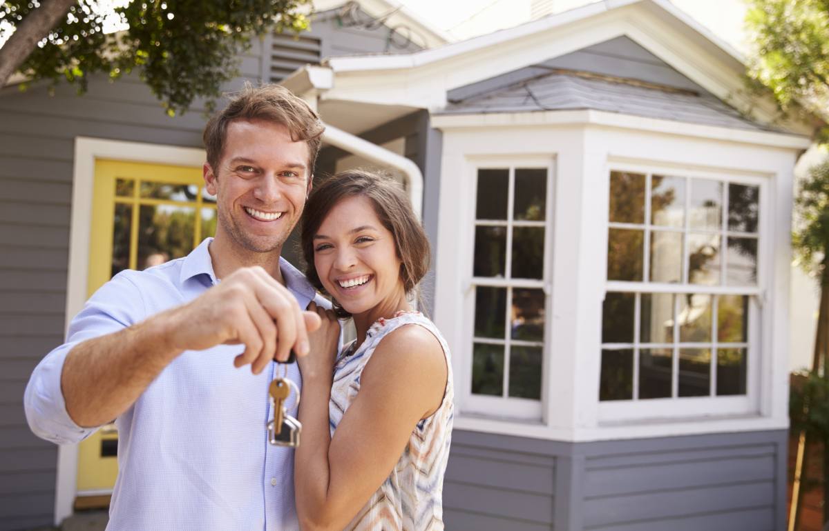 A couple holding keys to their new house