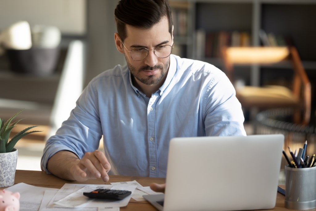 A man completes a mortgage application on his laptop computer. 