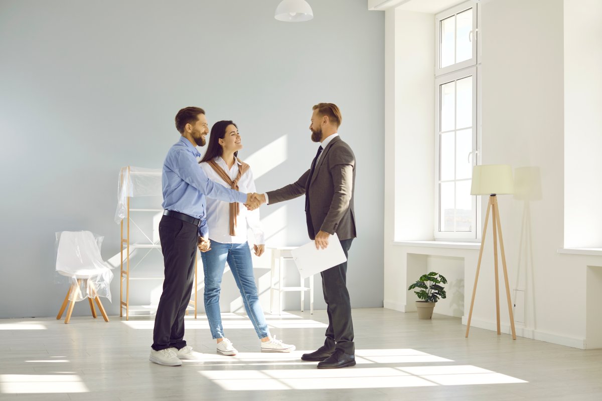 A couple shaking hands with a realtor