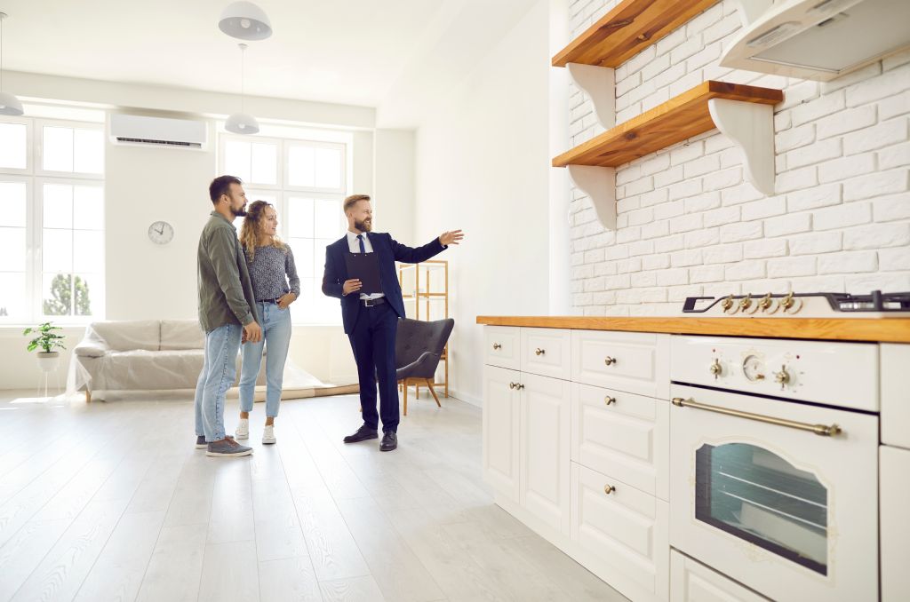 A couple tours a home with their real estate agent. 
