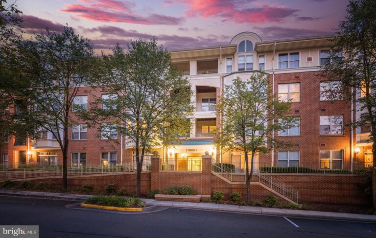 Brick condominium building at dusk, 1855 Stratford Park Place 303, Reston, VA