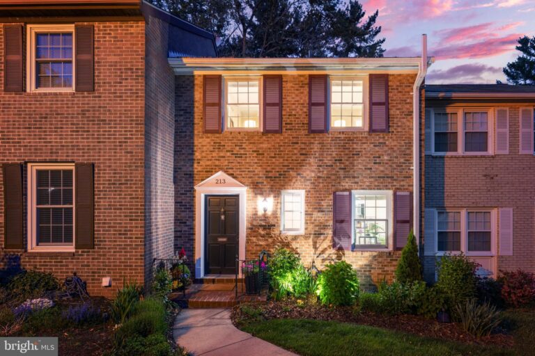 Brick townhome with lit front door at dusk, 213 Commons Drive NW, Vienna, VA