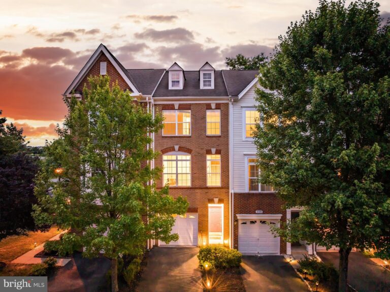 Three-story townhome with garage at dusk, 20404 Trails End Terrace, Ashburn, VA