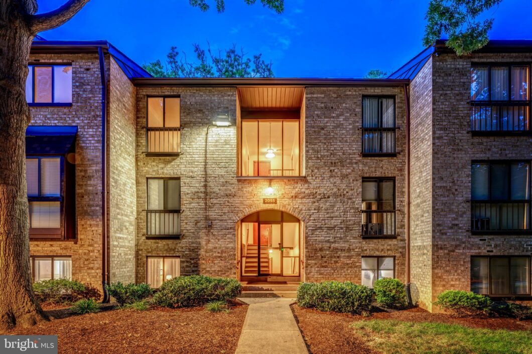 Brick condominium building entrance at dusk, 2055 Royal Fern Court 1B, Reston, VA