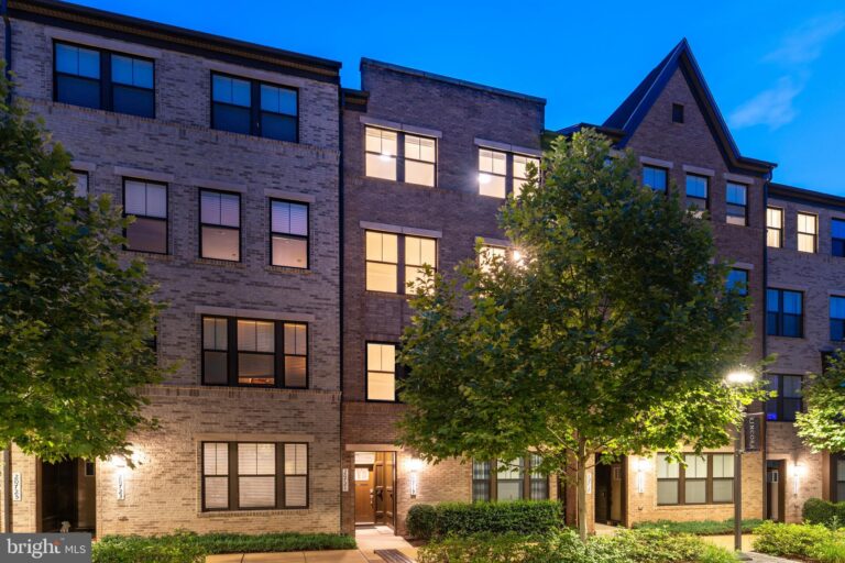 Four-story brick townhome building at dusk, 20721 Heron Landing Drive, Sterling, VA