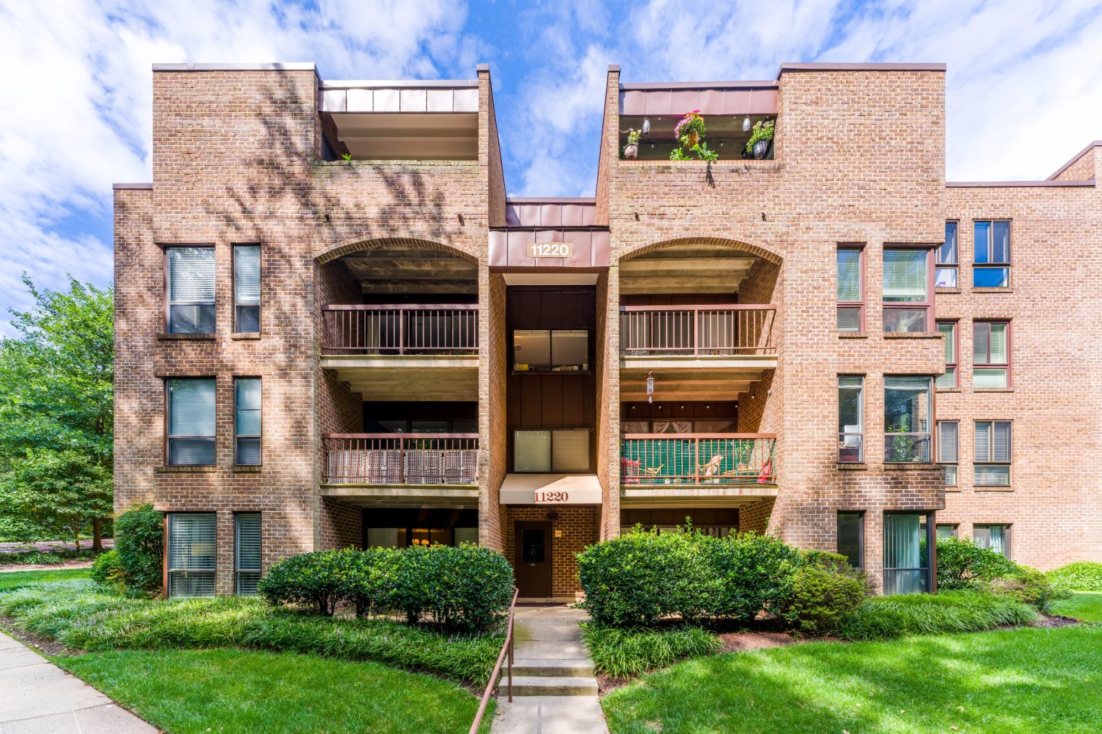 Brick low-rise condominium building with balconies at Chestnut Grove in Reston VA