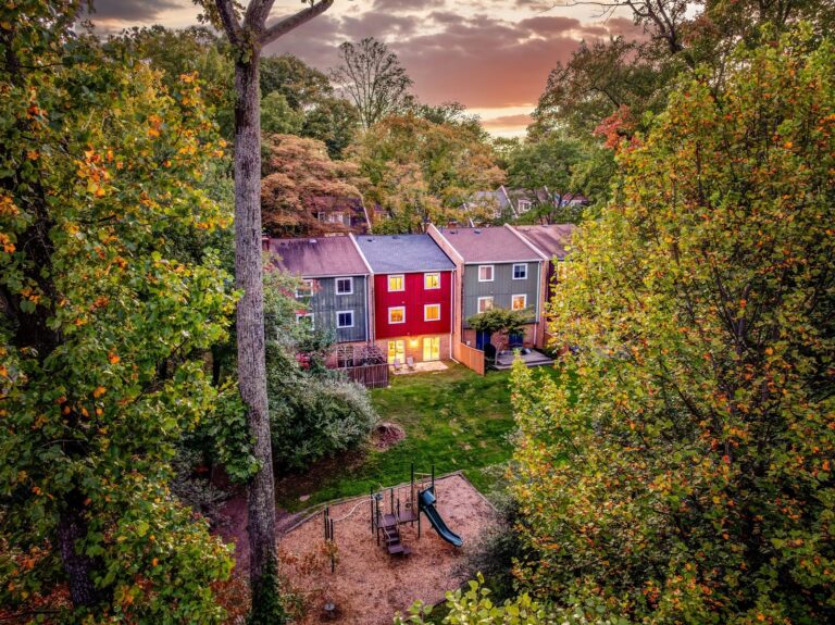 Aerial view of colorful Forest Edge townhomes in Reston VA surrounded by fall trees, with a tot lot in the common area