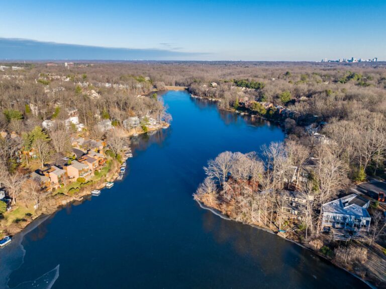 Aerial view of Lake Audubon in Reston, Virginia, with lakefront homes and the Reston skyline on the horizon