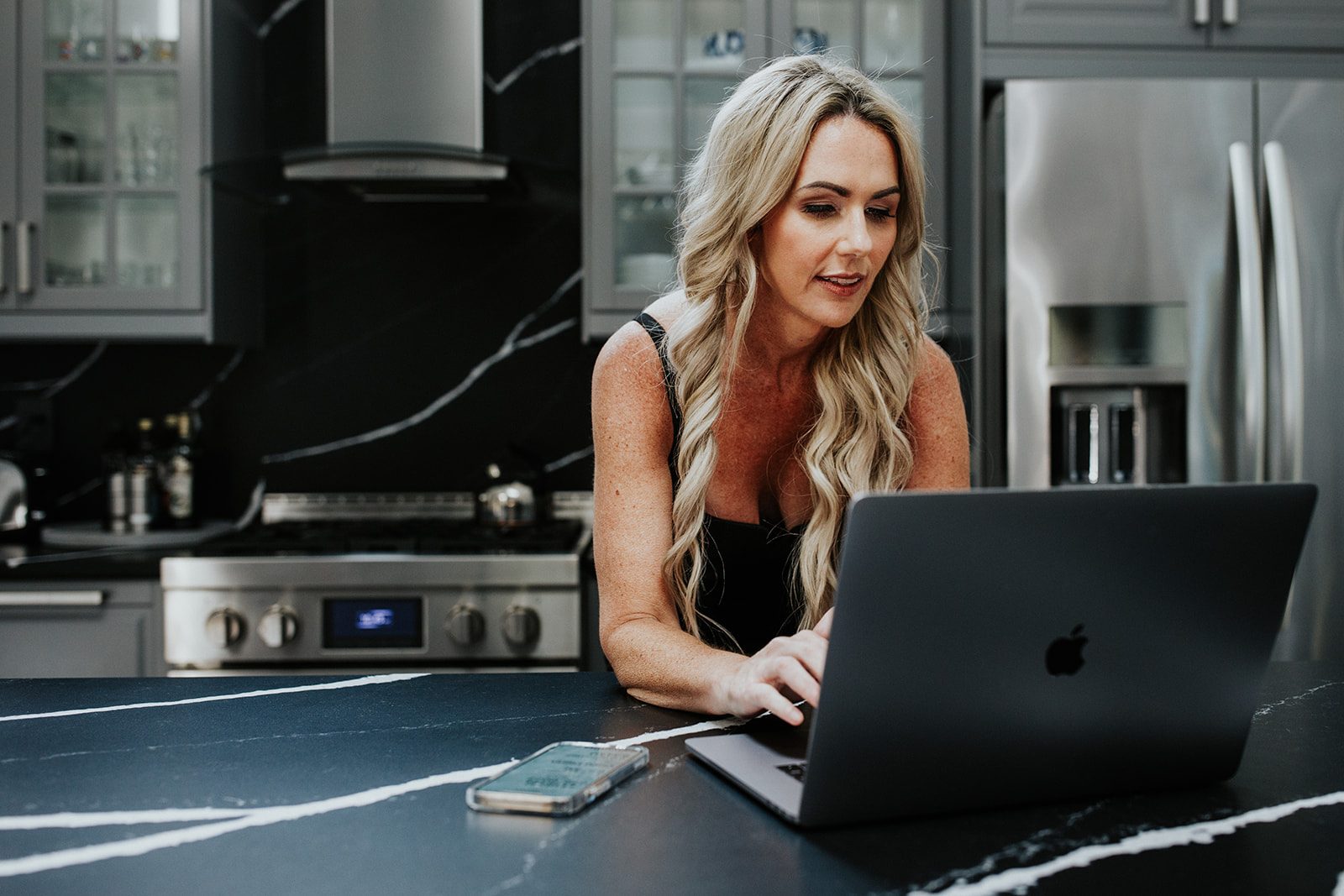 Nikki Lagouros preparing a written cash offer on a laptop at a kitchen counter