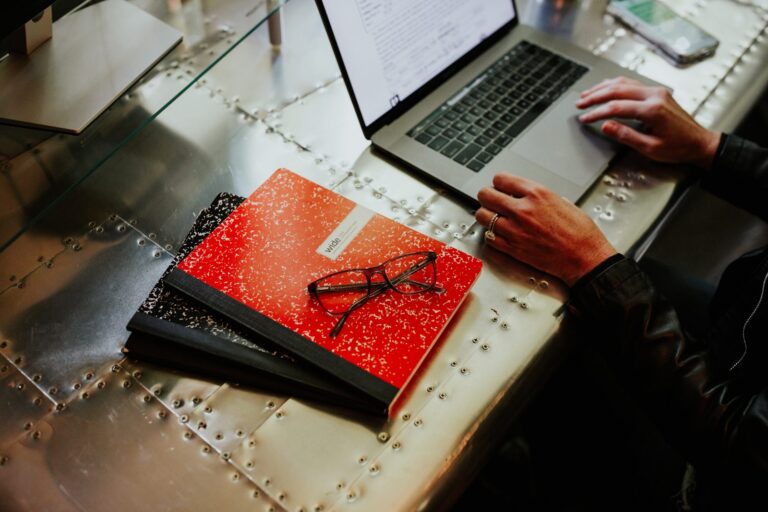 Nikki Lagouros reviewing comparable sales on a laptop with a notebook and reading glasses