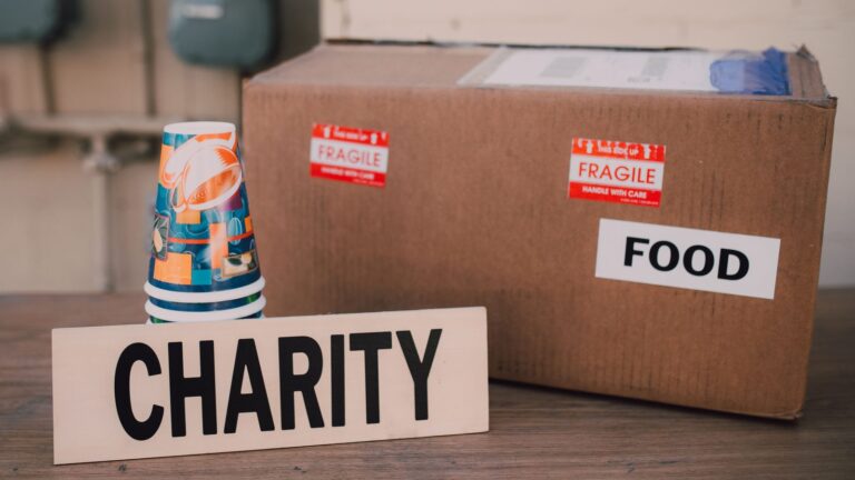 Cardboard box labeled FOOD beside a CHARITY sign, illustrating the 2026 Reston Thanksgiving food drive for Cornerstones in Reston, VA